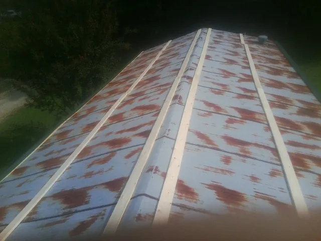 Rusted metal roof panels with new wood purlins before replacement — Storm Damage Roof Repair in Barco by Roofing Brothers