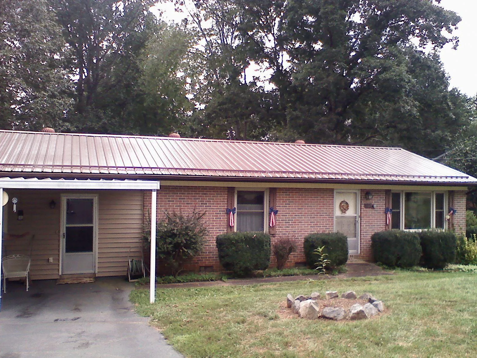 Bronze metal roof and carport on a brick ranch home — Roof Repair work by our crew in Barco